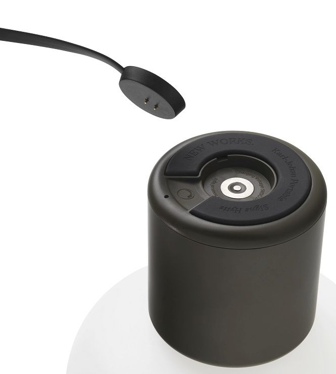 Detailaufnahme der Karl-Johan Akkuleuchte von New Works in Waldgrün mit Ladekabel.