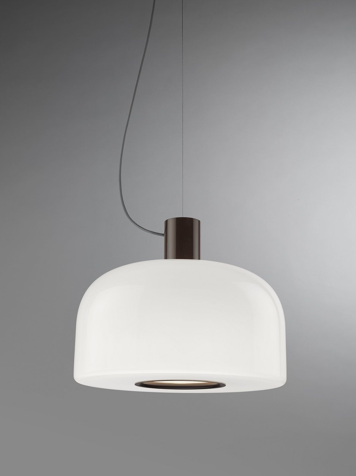 Nahaufnahme der Bellhop Pendelleuchte von Flos mit weißem Glasschirm und braunem Baldachin.