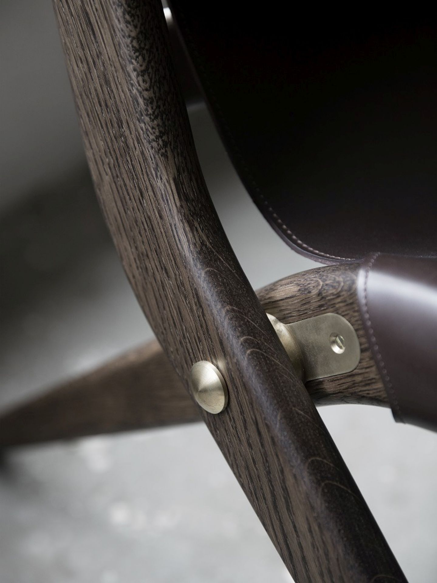 Detailaufnahme Saxe Chair: Braunes Leder, braun gebeiztes Eichenholz und Messingbeschläge. Design Stuhl.