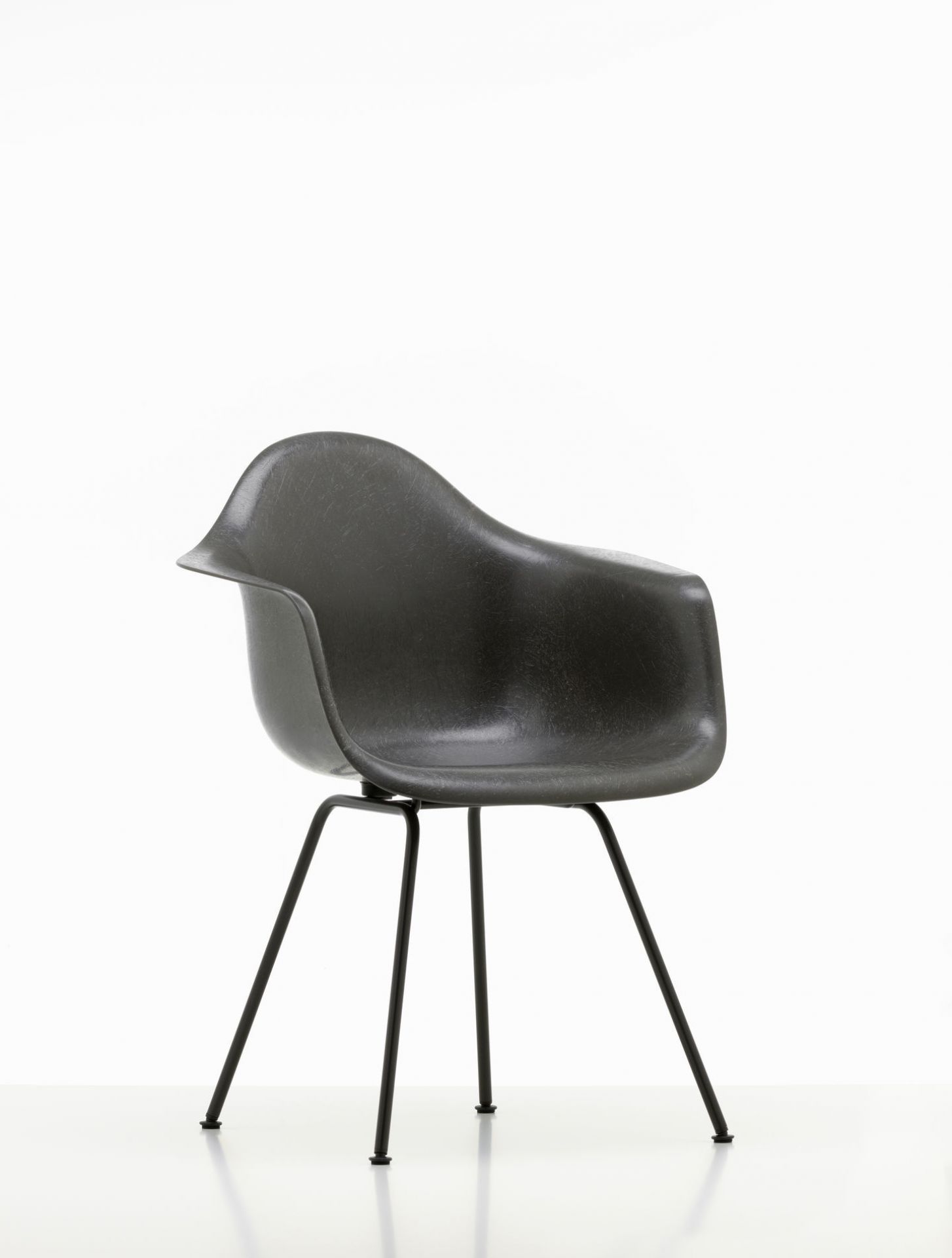 Schwarzer Eames Plastic Arm Chair DAX Stuhl von Vitra mit schwarzem Metallgestell vor weißem Hintergrund.