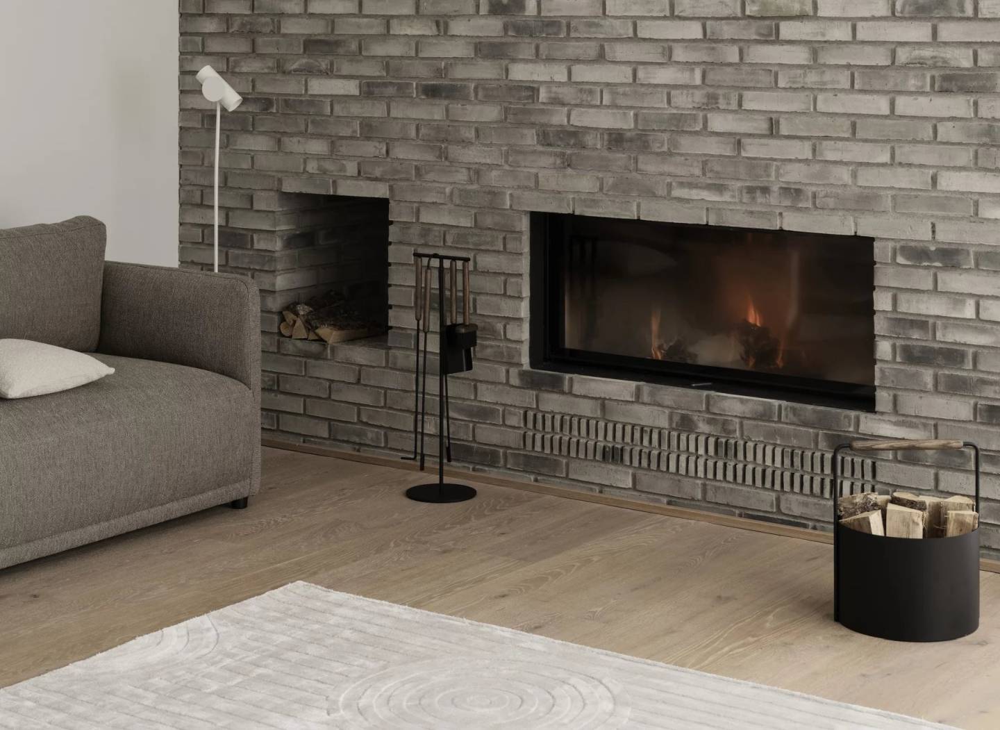 Uzu Rug Teppich B 160 x L 240 cm Blomus Taupe vor Kamin und Sofa.