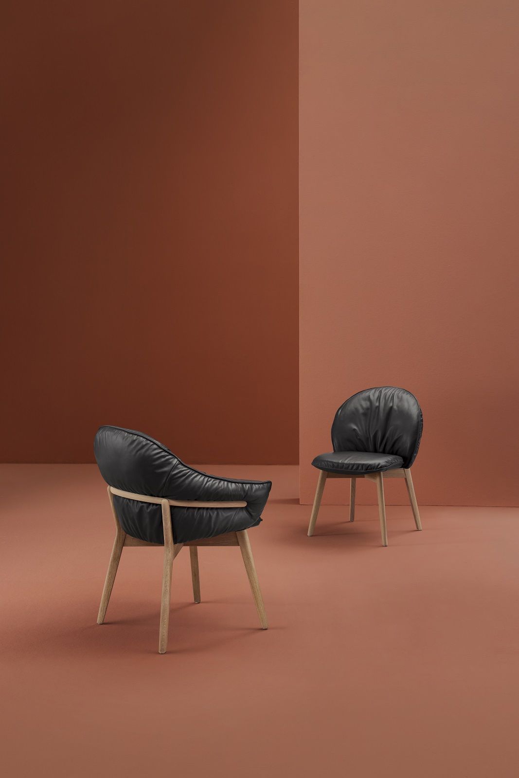 Zwei Marie Armchair Sessel von Freifrau Manufaktur mit schwarzem Leder und Holzbeinen.