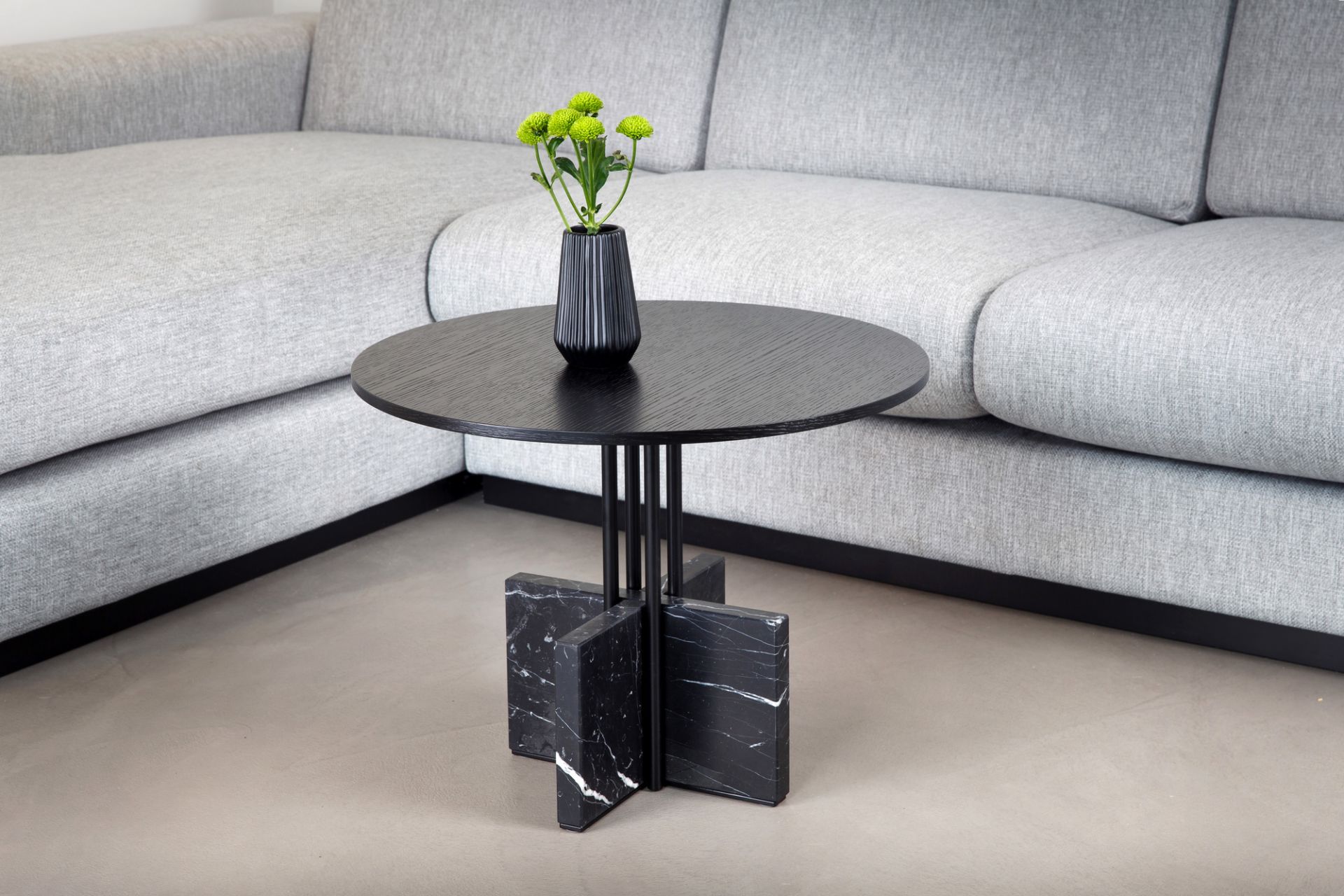 Gravity Table Beistelltisch: Runder, schwarzer Couchtisch mit Marmorfuß und Vase mit grünen Blumen.