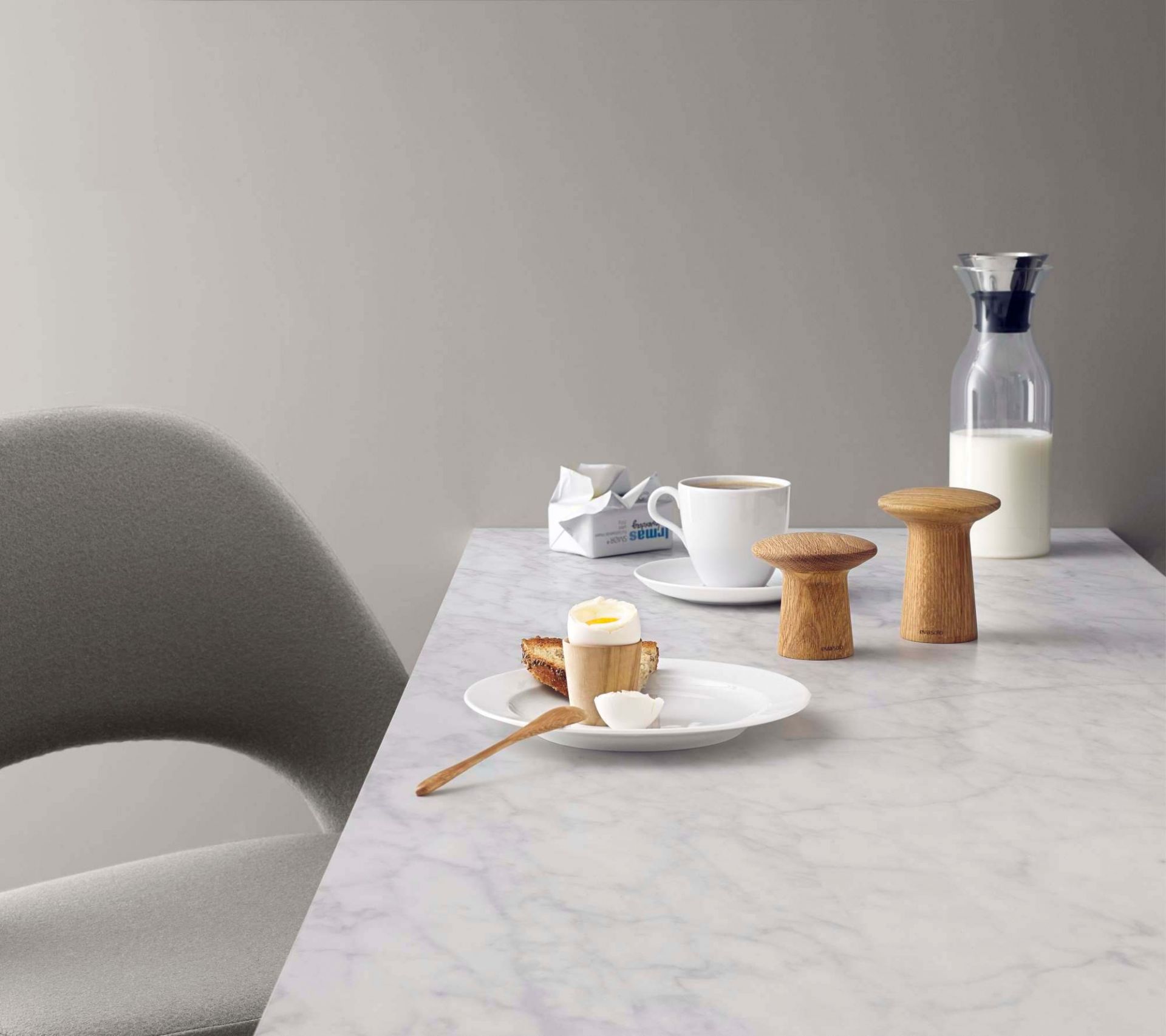 Nahaufnahme von Eva Solo Salz- und Pfeffermühlen aus Holz auf einem gedeckten Frühstückstisch.