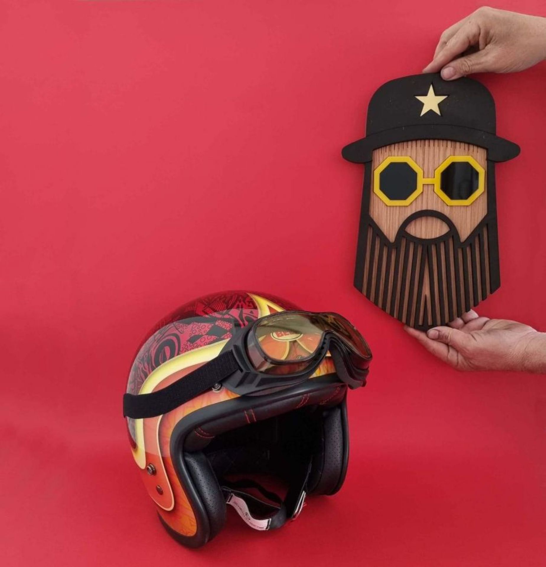 Hipster Morris Wandschmuck Umasqu: Handgefertigte Holzmaske und Motorradhelm vor rotem Hintergrund. Dekorative Wandkunst für stilvolle Interieurs.