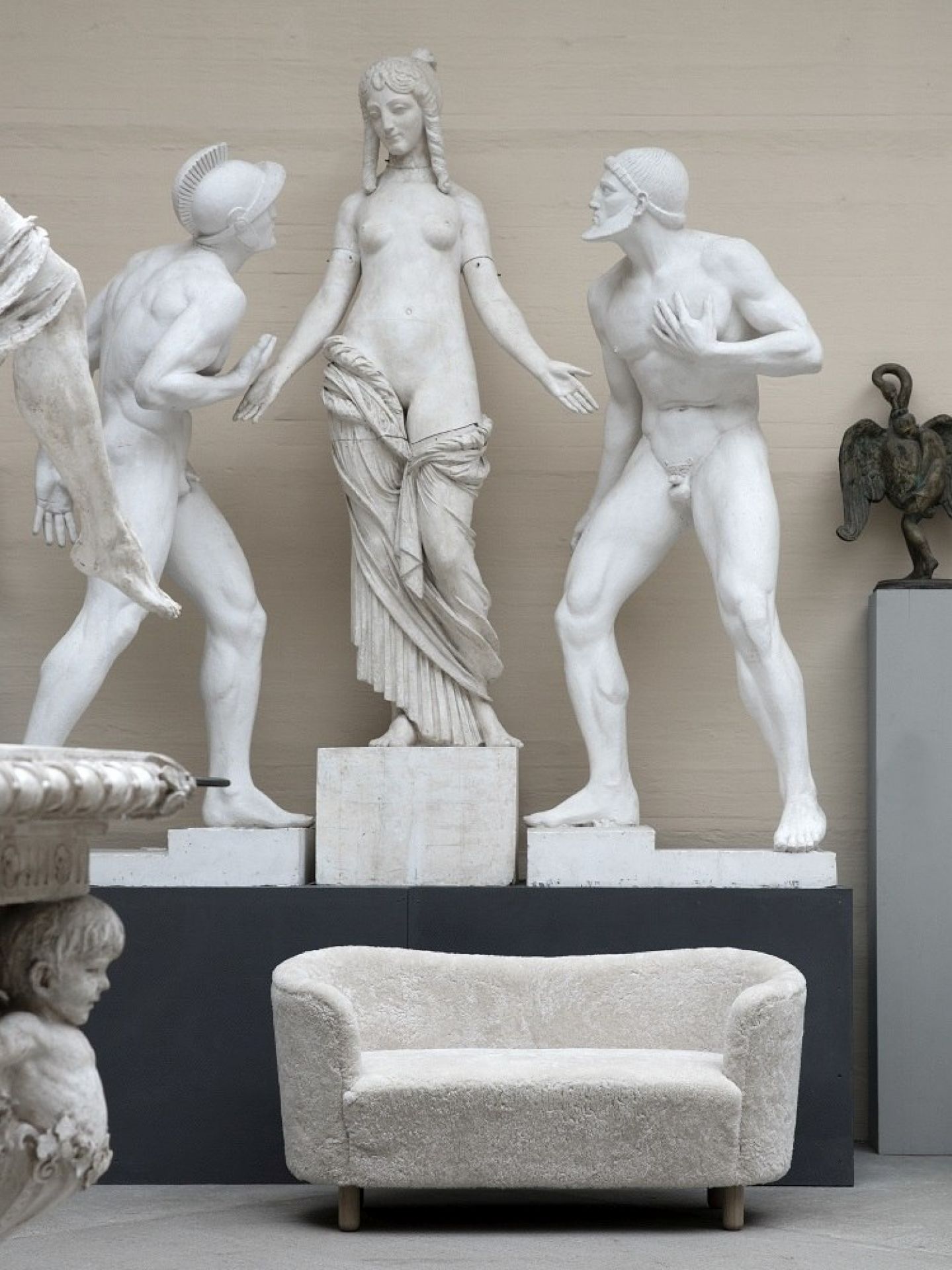 Beiges Audo Mingle Sofa 2-Sitzer vor Statuen. Modernes Sofa für Wohnzimmer und stilvolles Interieur.