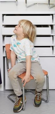 Kind sitzt auf einem S 43 K Kinderstuhl Freischwinger von Thonet, Blick nach oben.