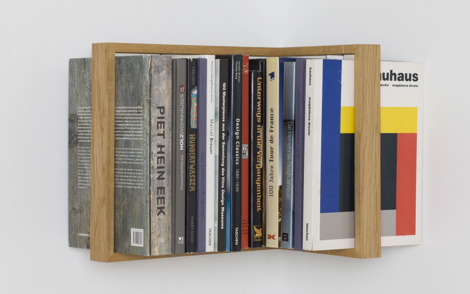 Regal b-eck3 Eiche, das kleine b: Bücherregal aus hellem Eichenholz, gefüllt mit Design- und Architekturbüchern.