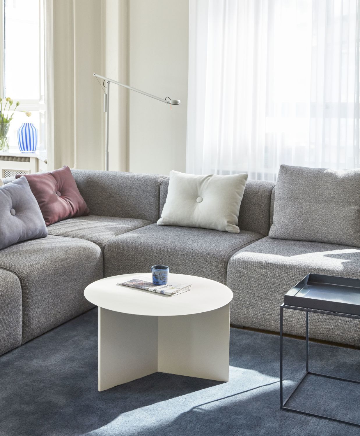 Weißer Slit Table Round Beistelltisch von Hay im Wohnzimmer neben einem grauen Sofa.