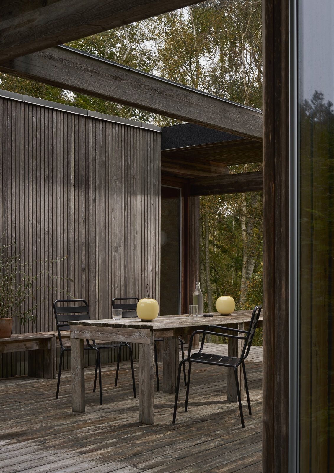 VL 45 Radiohus Tischleuchte von Louis Poulsen auf einem Holztisch im Außenbereich.