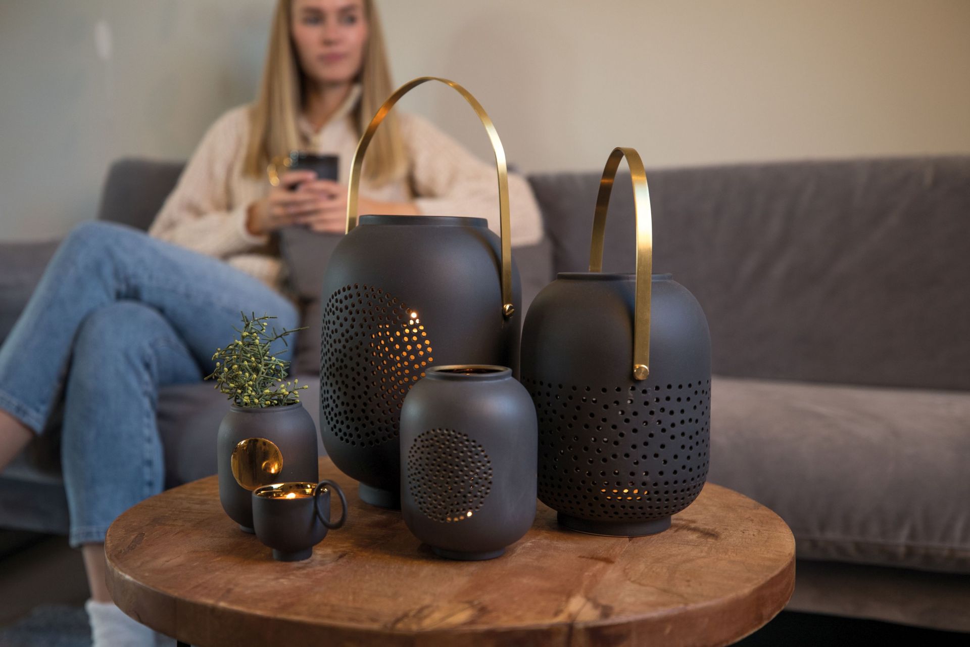 Dekorative Zuhausesein Laterne Mond Räder EINZELSTÜCK aus Keramik in Anthrazit mit goldenen Akzenten auf Holztisch.