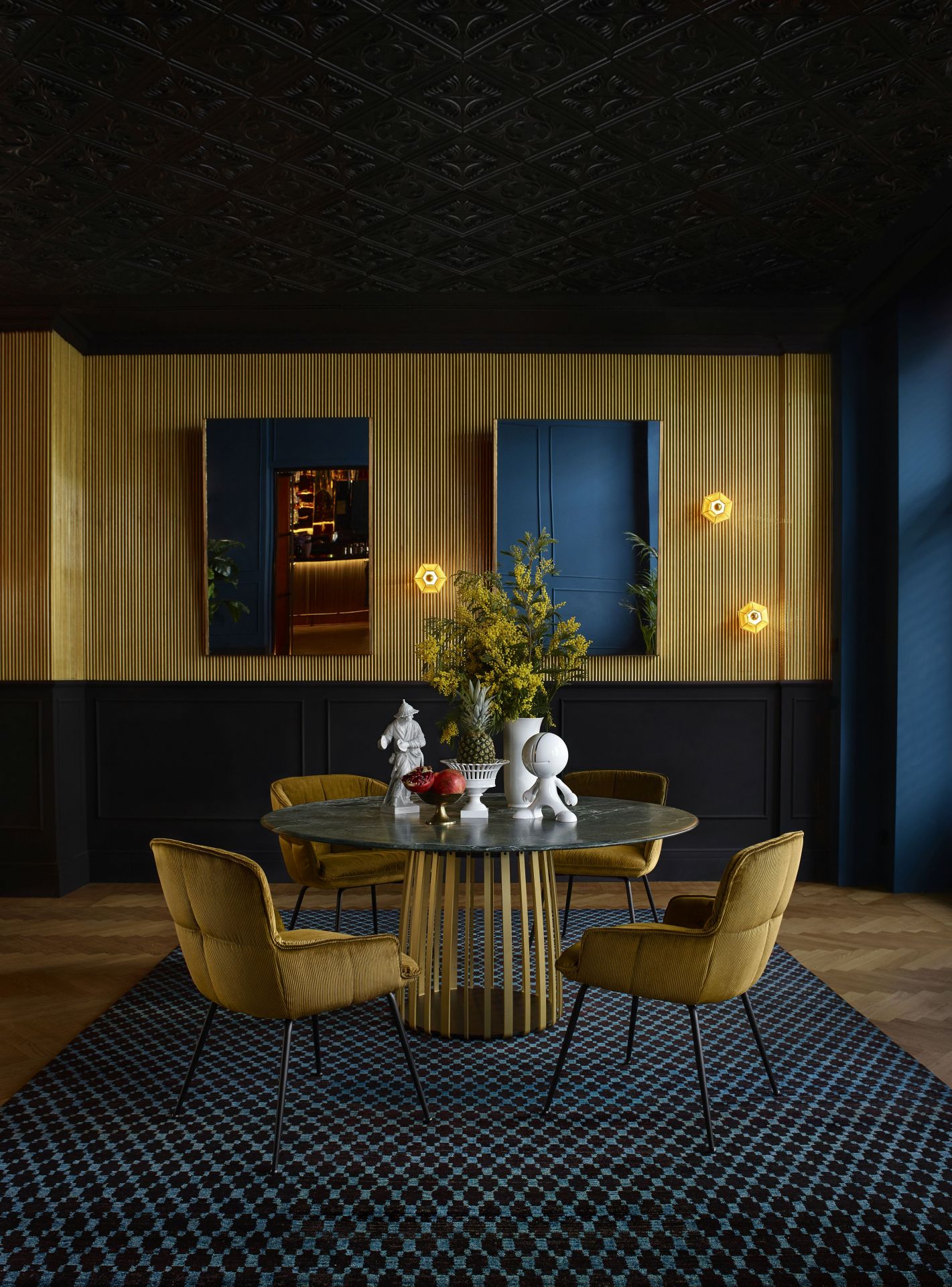 Esszimmer mit vier Marla Armlehnstühlen von Freifrau Manufaktur in Senfgelb um einen runden Tisch.