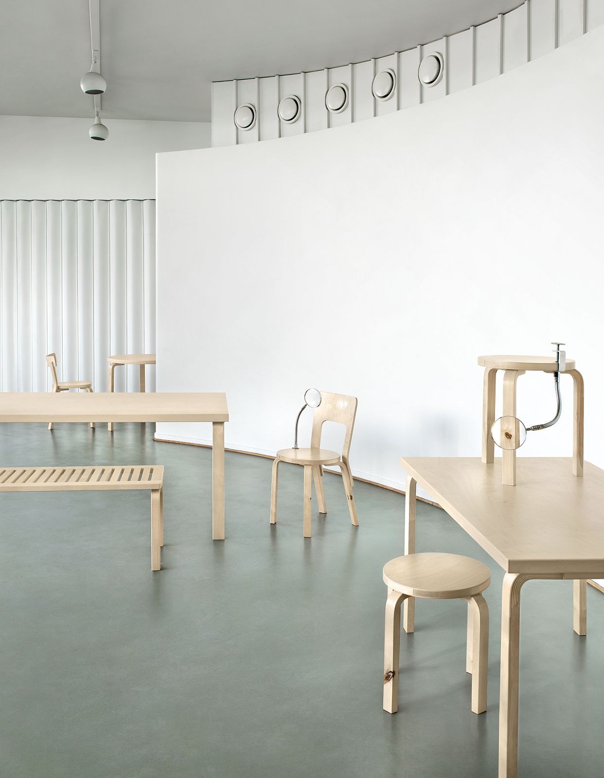 Helle Artek Bank und weitere Holzmöbel in minimalistischem Raum, Fokus auf Bench 153A.