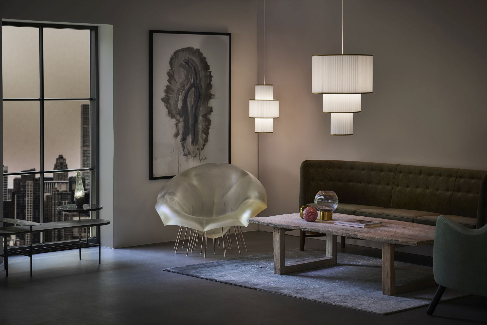 Wohnzimmer mit Le Klint Plivello Pendelleuchten, Designermöbeln und gedämpftem Licht für gemütliche Atmosphäre.