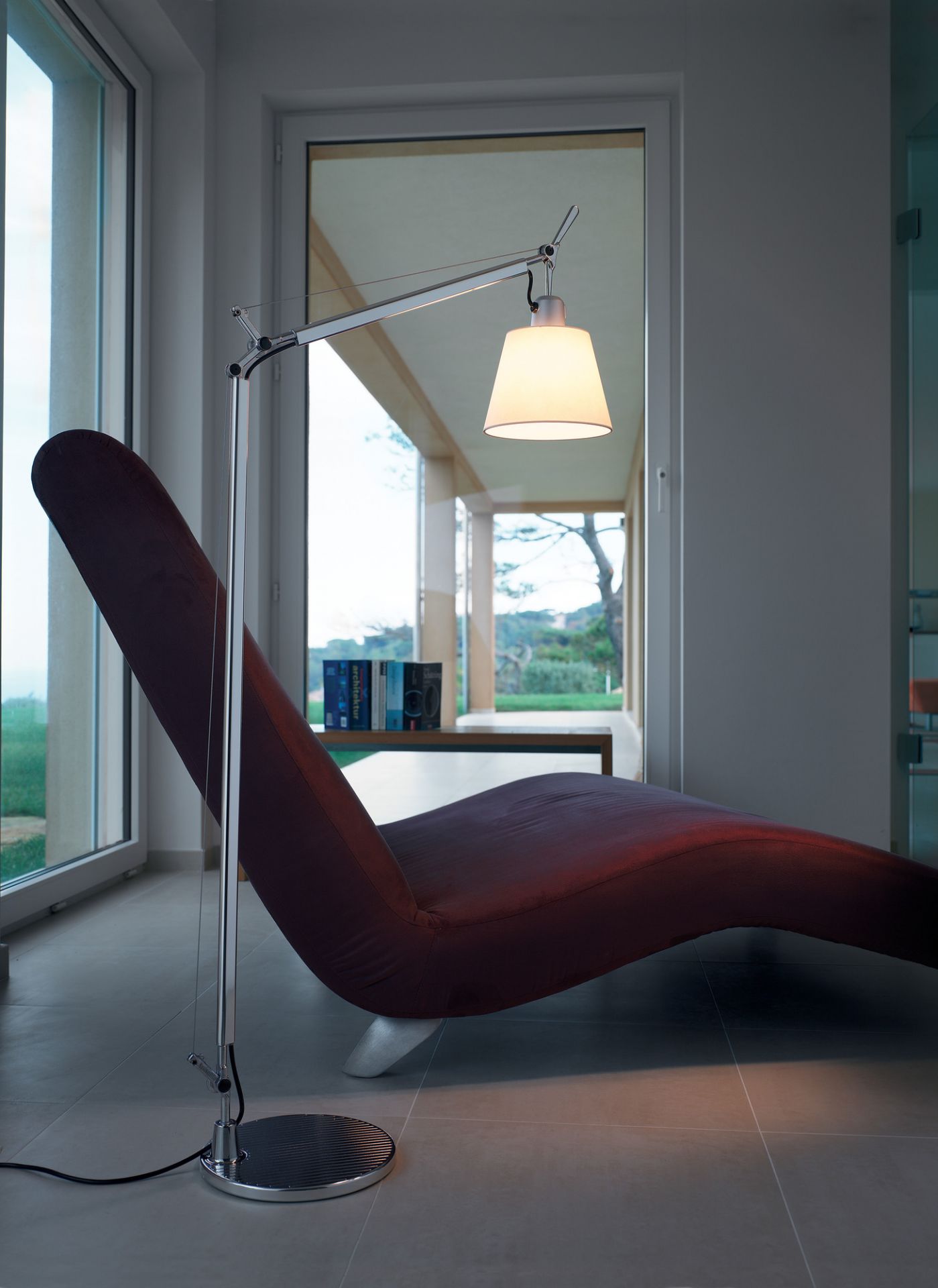 Artemide Tolomeo Basculante Stehleuchte mit Schirm neben Liege, modernes Design für Wohnzimmer und Leseecke.