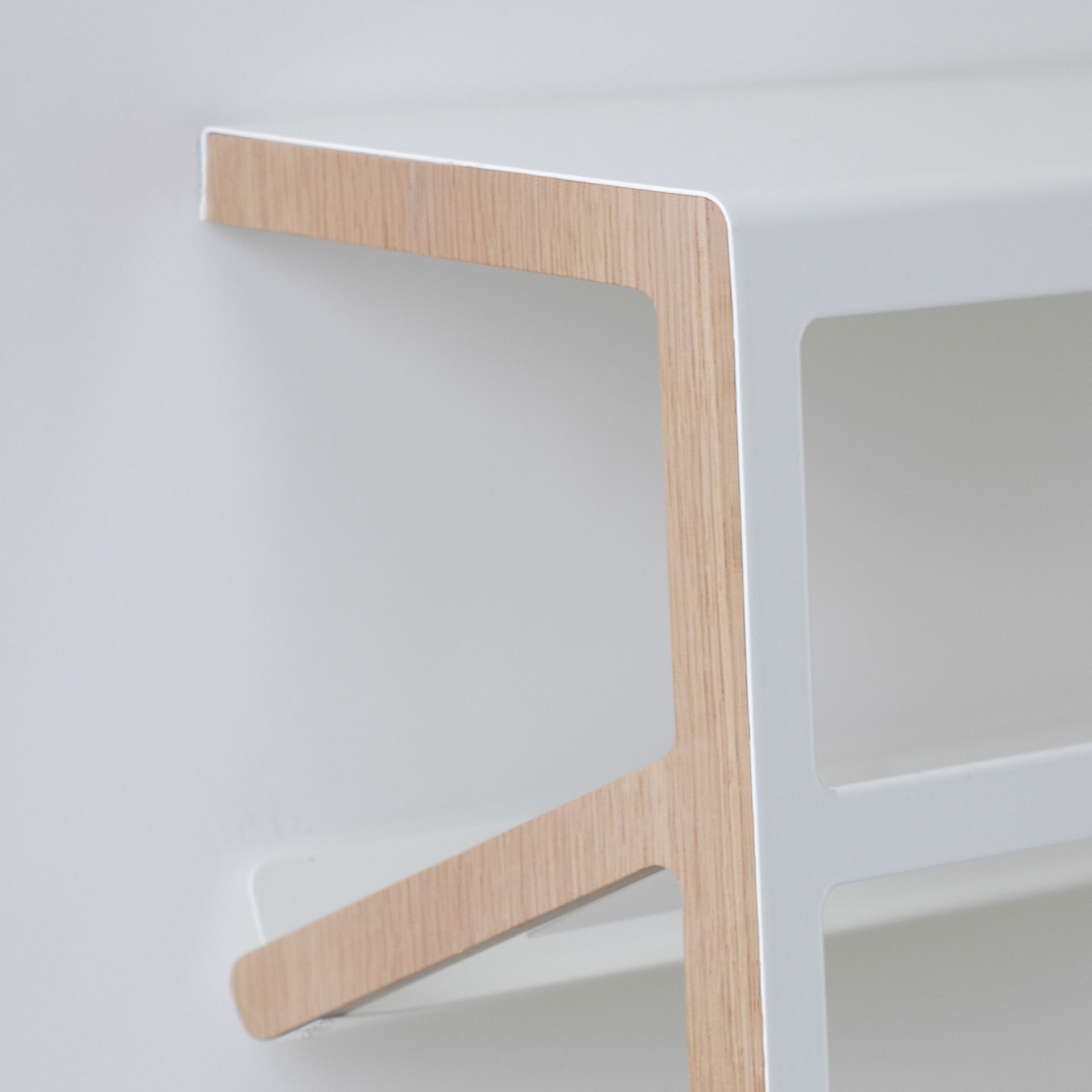 Detailaufnahme des Mila Schuhregals mit weißem Rahmen und Holzdetails. Modernes Design für die Schuhaufbewahrung.