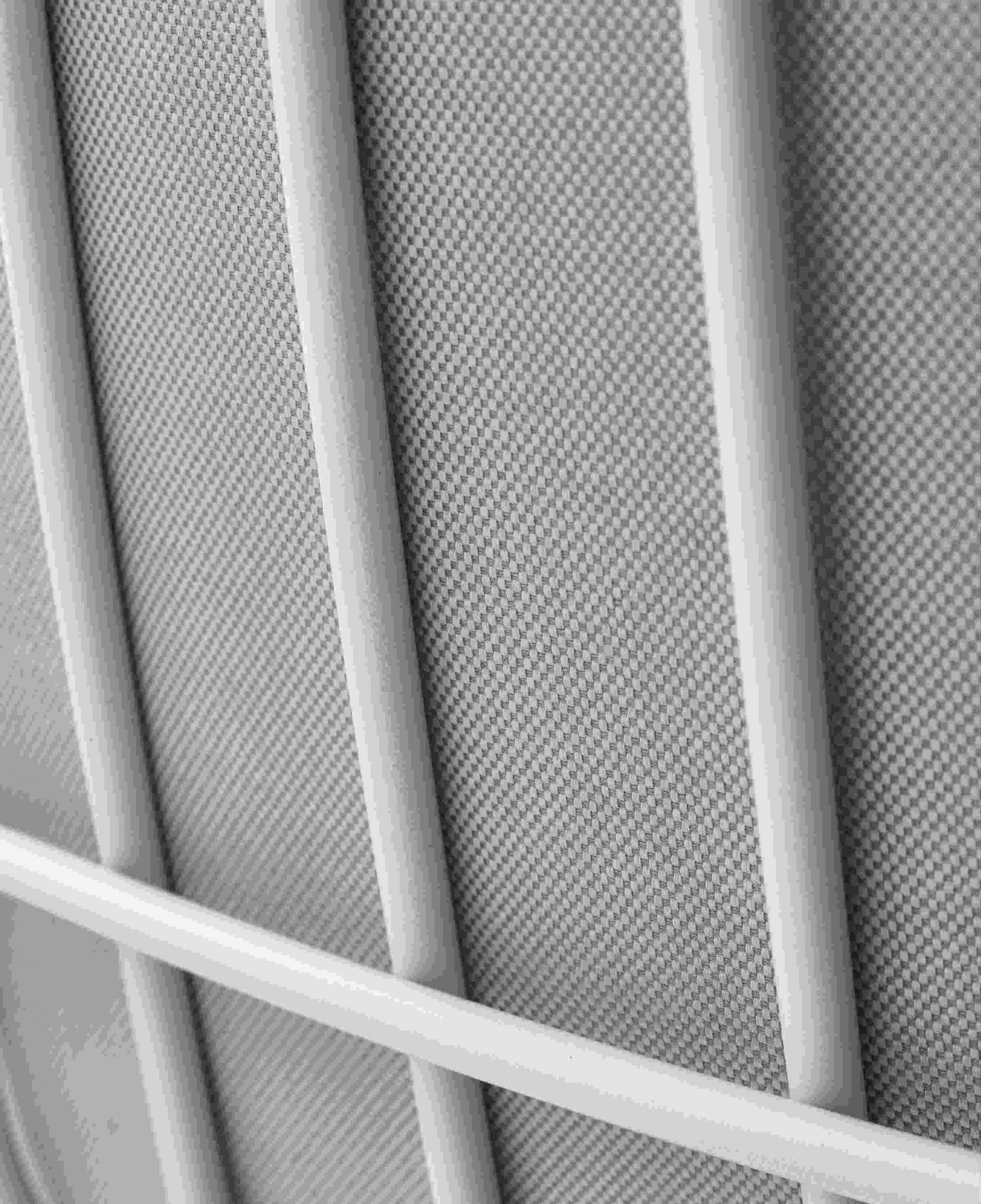 Detailaufnahme des Leyasol Lounge Chair von Freifrau Manufaktur: Weißes Metallgestell und grauer Outdoor-Stoff.