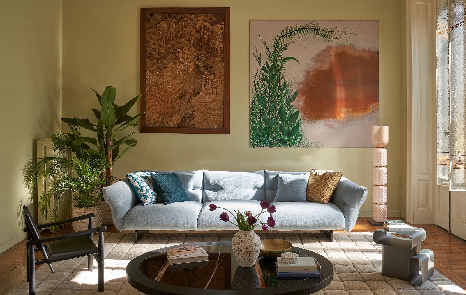 Helles Wohnzimmer mit Moncloud Sofa, Design-Möbeln und Kunstwerken an der Wand.