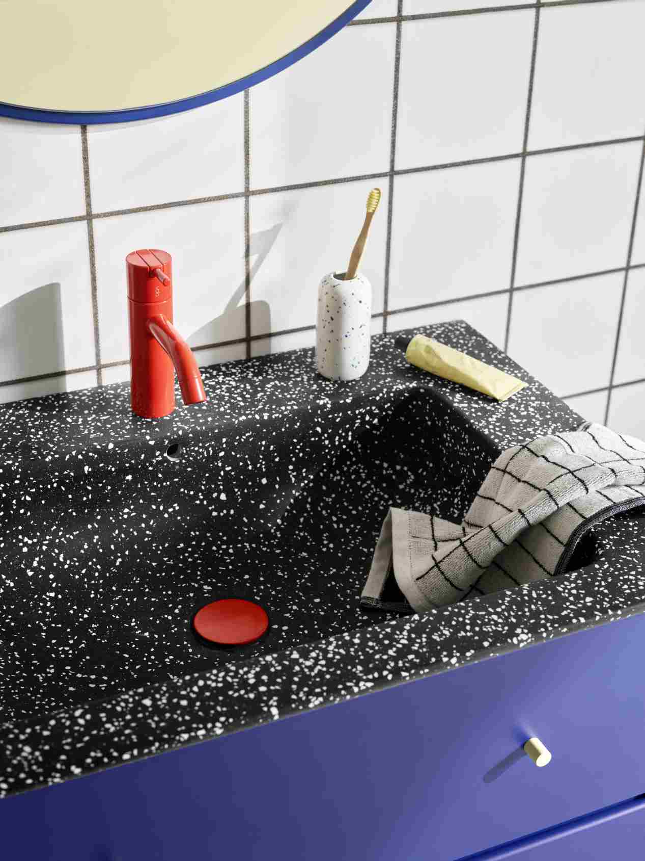 Detailaufnahme eines Waschbeckens mit Armatur und Accessoires; Montana Rosehip Spiegel im Hintergrund sichtbar.