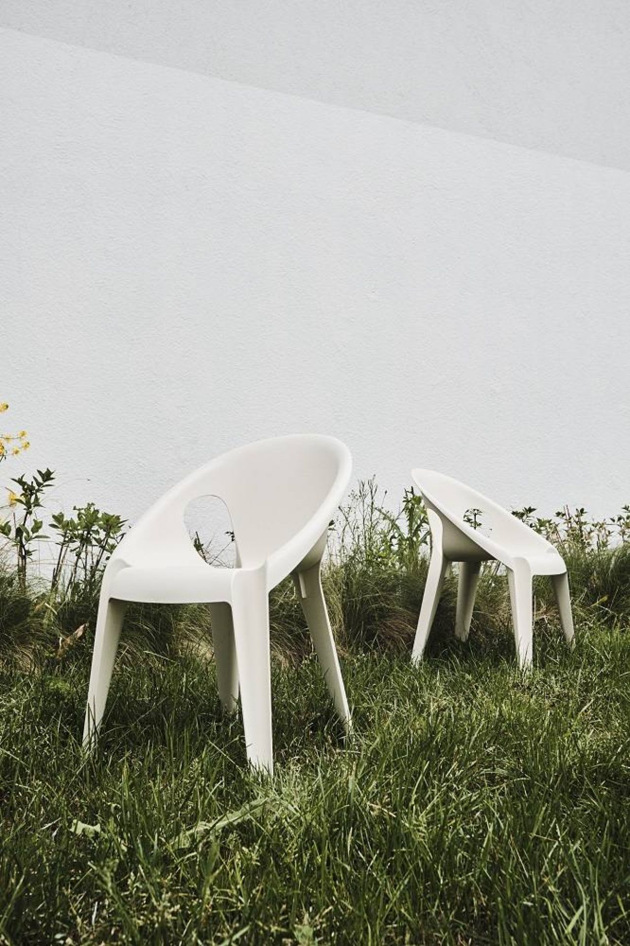Zwei weiße Bell Chairs von Magis High-noon im Freien, stapelbare Gartenstühle mit Armlehnen.