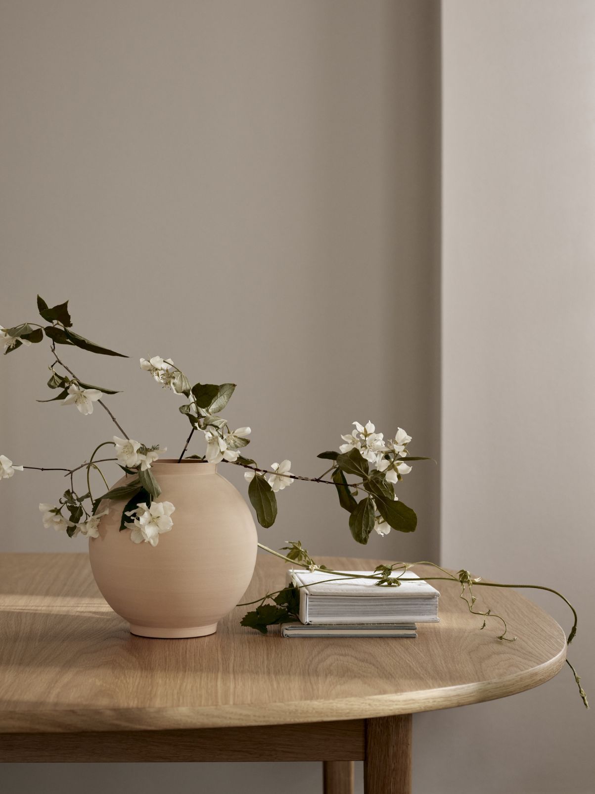 OW224 Tisch von Carl Hansen: Runder Holztisch mit Vase und Blumen.