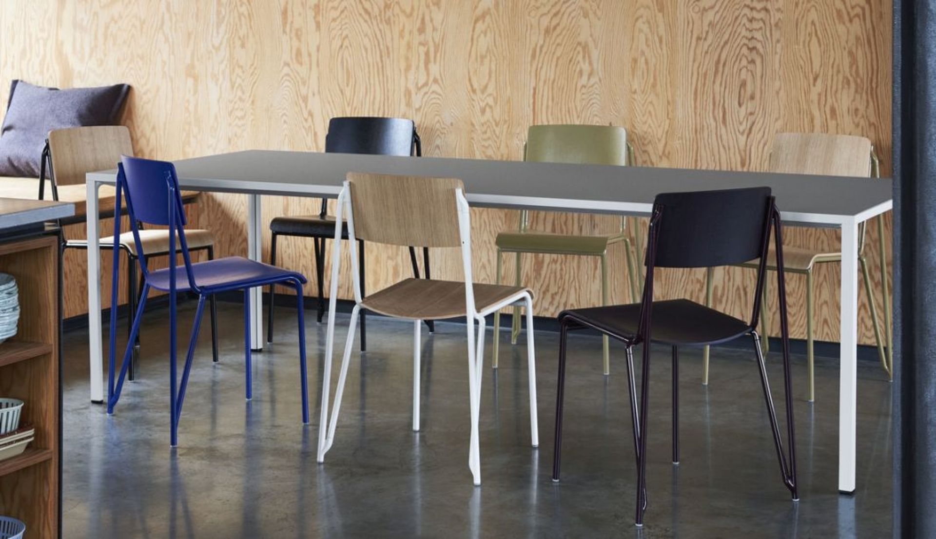 Mehrere Hay Stühle, darunter Petit Standard Stühle, in verschiedenen Farben an einem Esstisch.