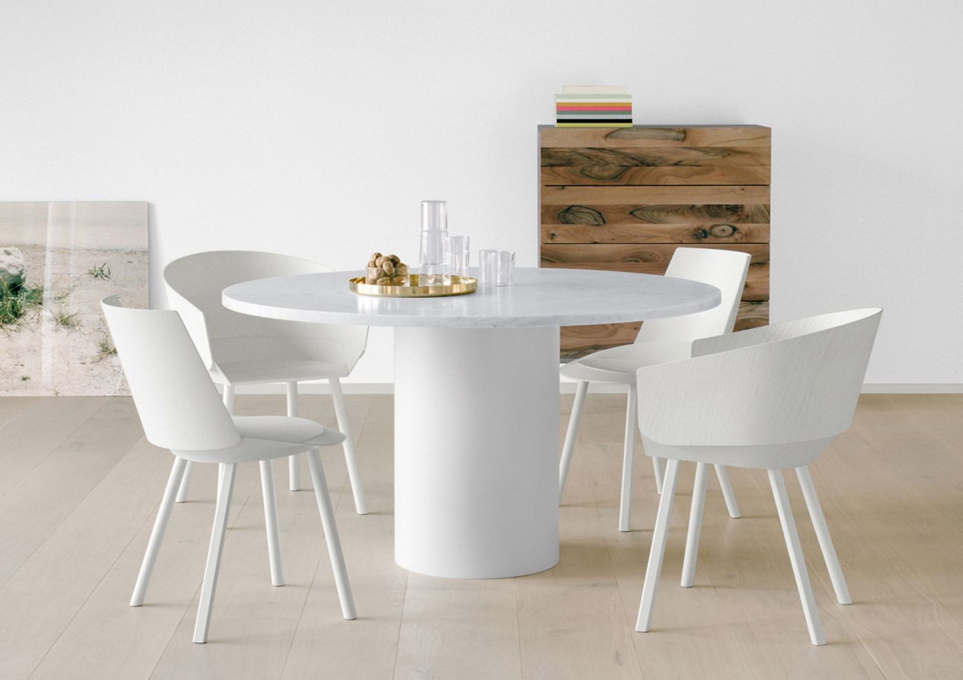 Runder Esstisch Hiroki mit Marmorplatte Bianco Carrara und weißen Stühlen im modernen Esszimmer.