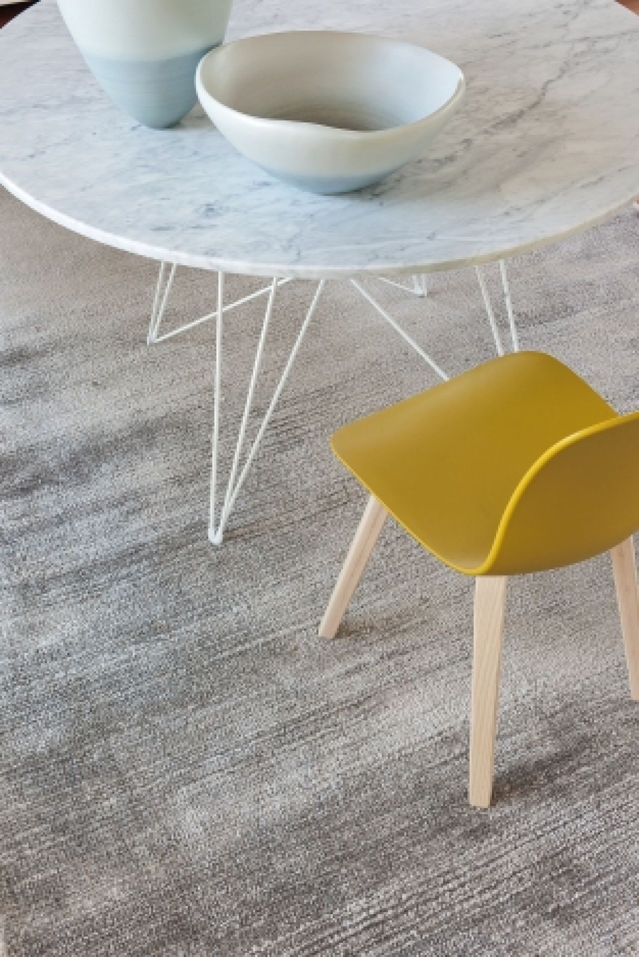 Runder Magis Tavolo XZ3 Tisch mit Marmorplatte und weißem Drahtgestell, kombiniert mit gelbem Stuhl.