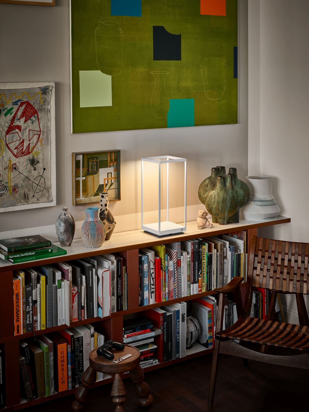 Weiße Reflex² Tischleuchte von Serien Lighting auf Regal mit Büchern und Dekoration. Moderne Lampe.