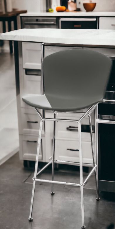 Nahaufnahme eines grauen Bertoia Barhockers mit verchromtem Gestell von Knoll International.