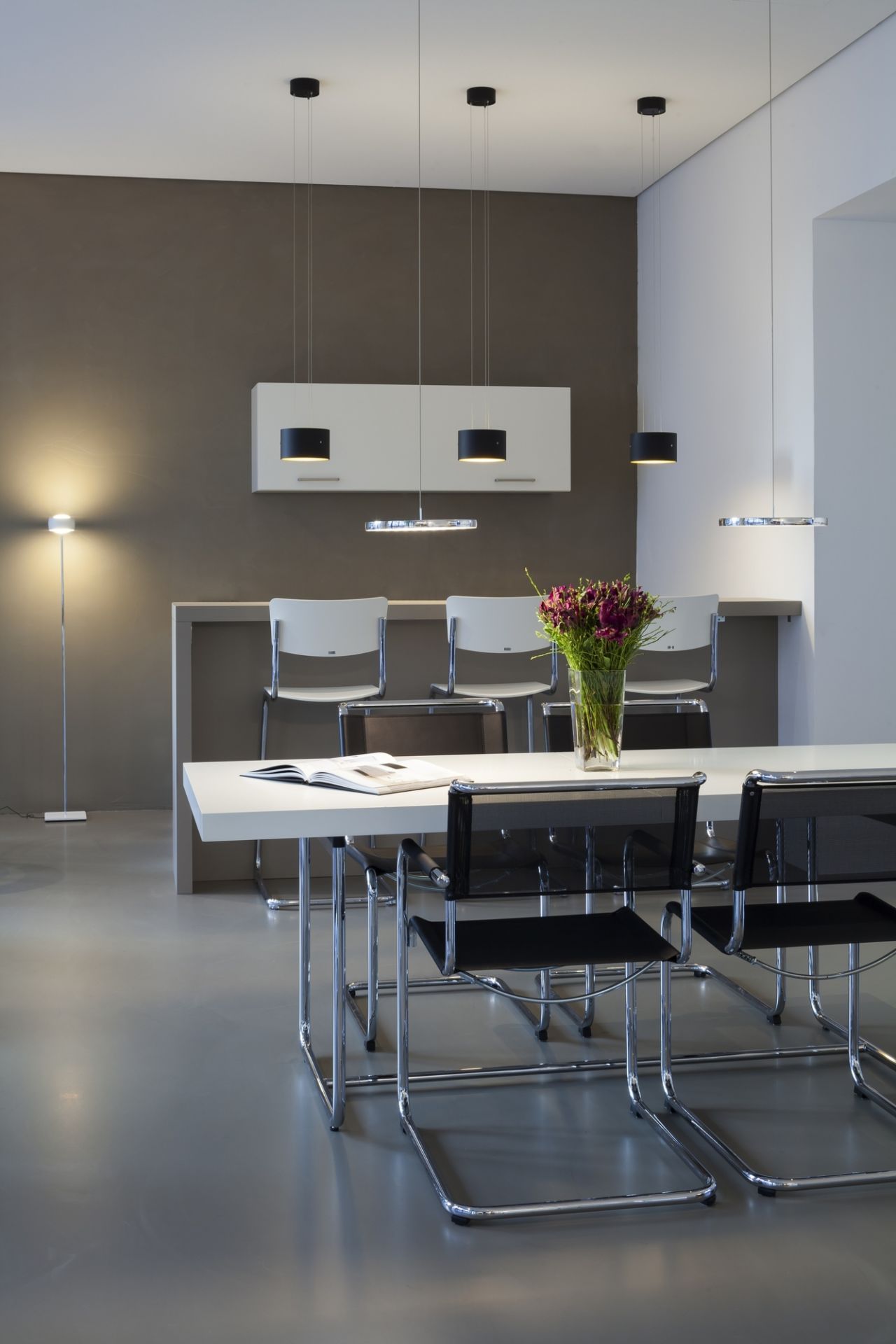 Moderner Essbereich mit weißem S 1070 Thonet Esstisch und Freischwinger Stühlen unter Pendelleuchten.