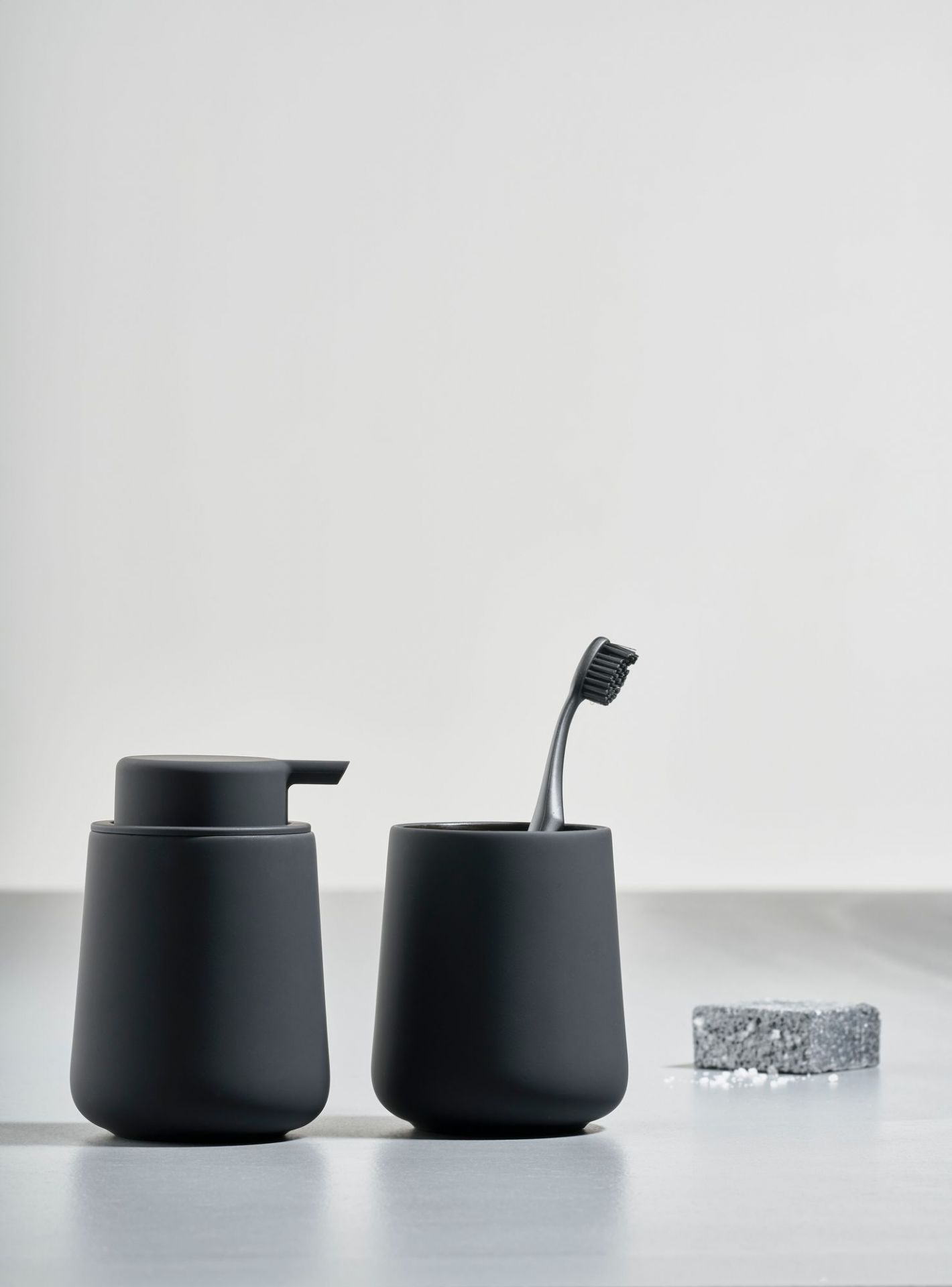 Zone Denmark Bad-Accessoires: Seifenspender, Zahnputzbecher und Seife in Anthrazit für moderne Badezimmergestaltung.