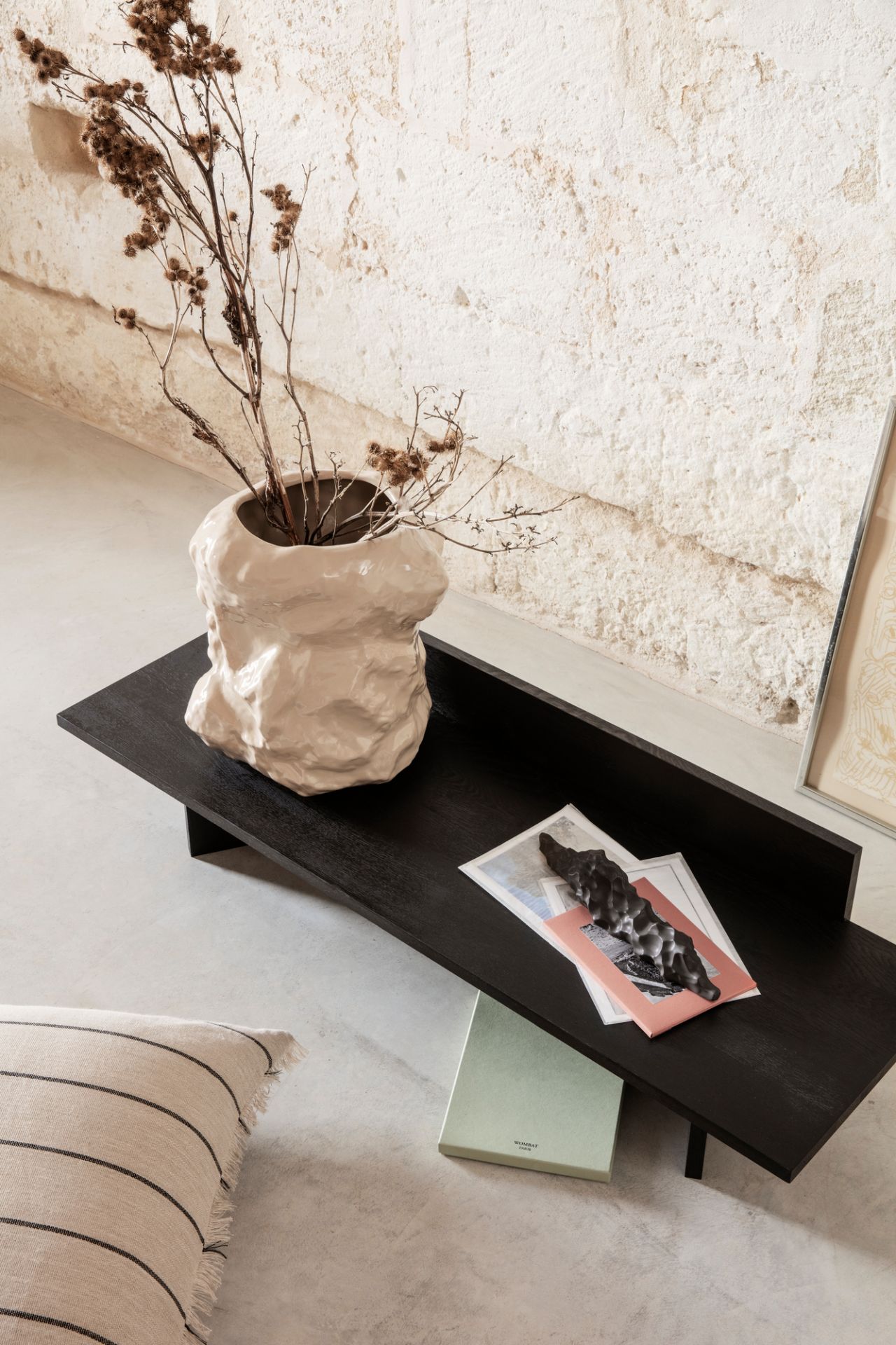 Schwarze Oblique Bank von Ferm Living mit abstrakter Vase und Deko-Elementen im modernen Interieur.