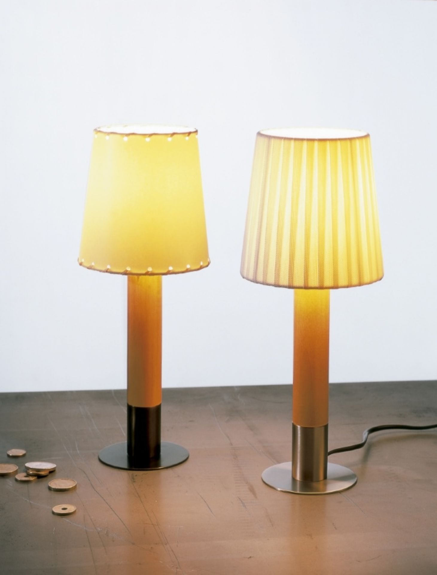 Zwei Basica Minima Tischleuchten von Santa & Cole mit Stoffschirmen auf einem Tisch.