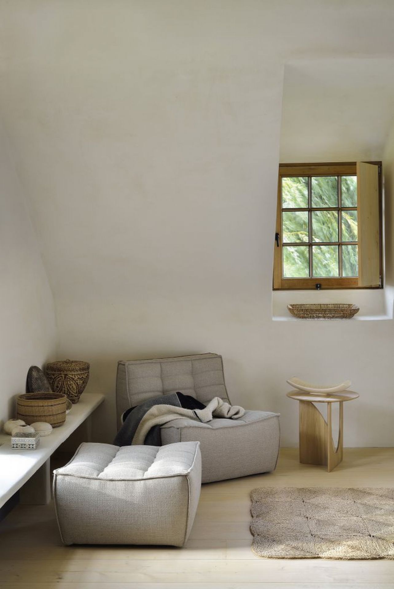 N701 Sofa Polsterhocker von Ethnicraft in hellem Raum mit Fenster und Deko-Elementen.