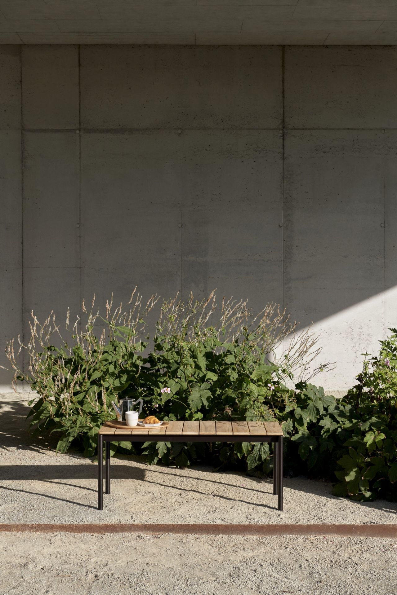 AndTradition Ville AV27 Outdoor Bank aus Teakholz mit Frühstück im Garten.