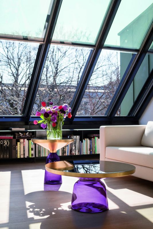 Moderner Bell Table Couchtisch von Classicon mit violetter Glasbasis und goldener Tischplatte im Wohnzimmer.