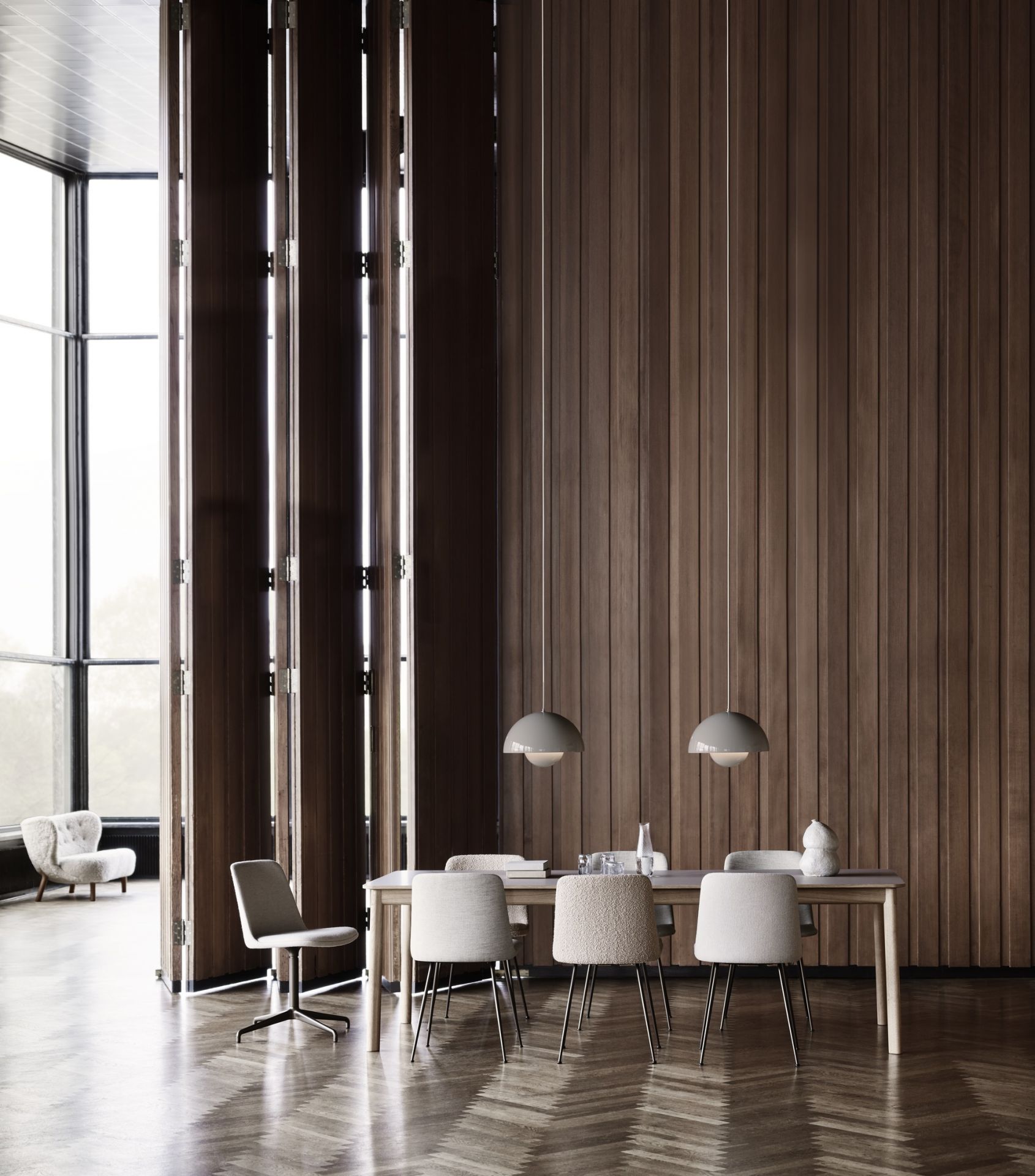 Esszimmer mit Esstisch und mehreren Rely HW65 Stühlen von AndTradition in Beige und Grau.