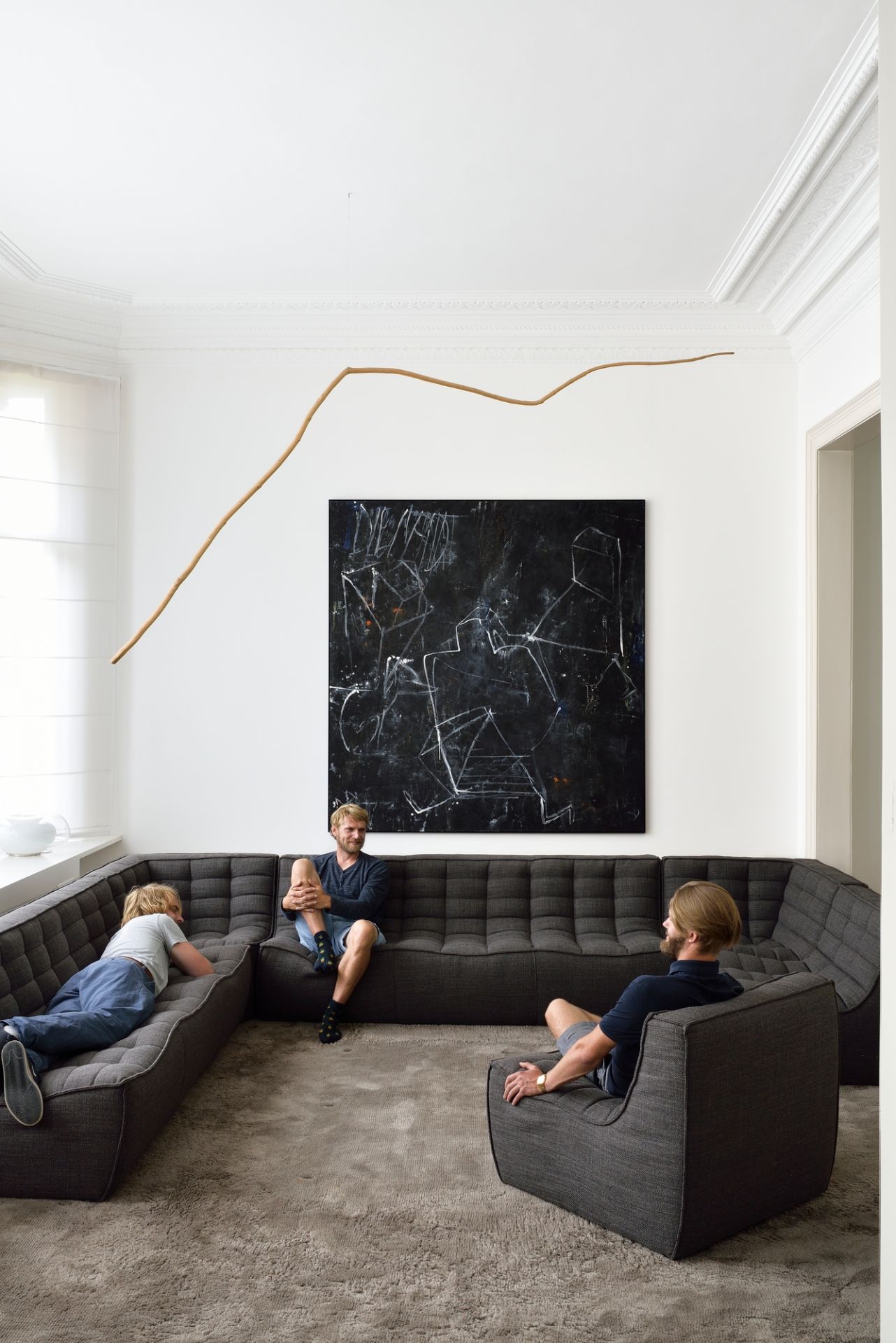 N701 Sofa von Ethnicraft: Graues 3-Sitzer Modulsofa mit Personen im modernen Wohnzimmer.