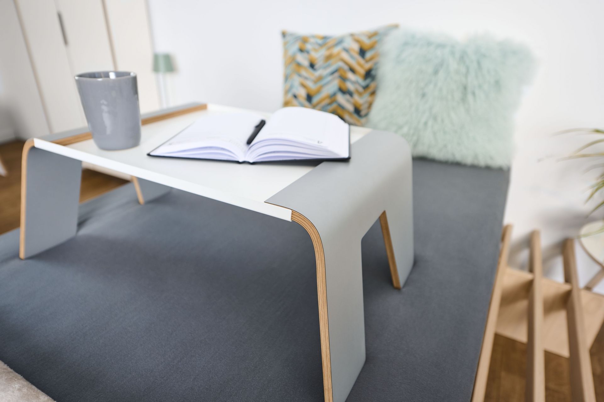 Tojo Notebook-Tablett auf Bett mit Notizbuch, Stift und Tasse. Praktischer Betttisch für Frühstück oder Arbeit.