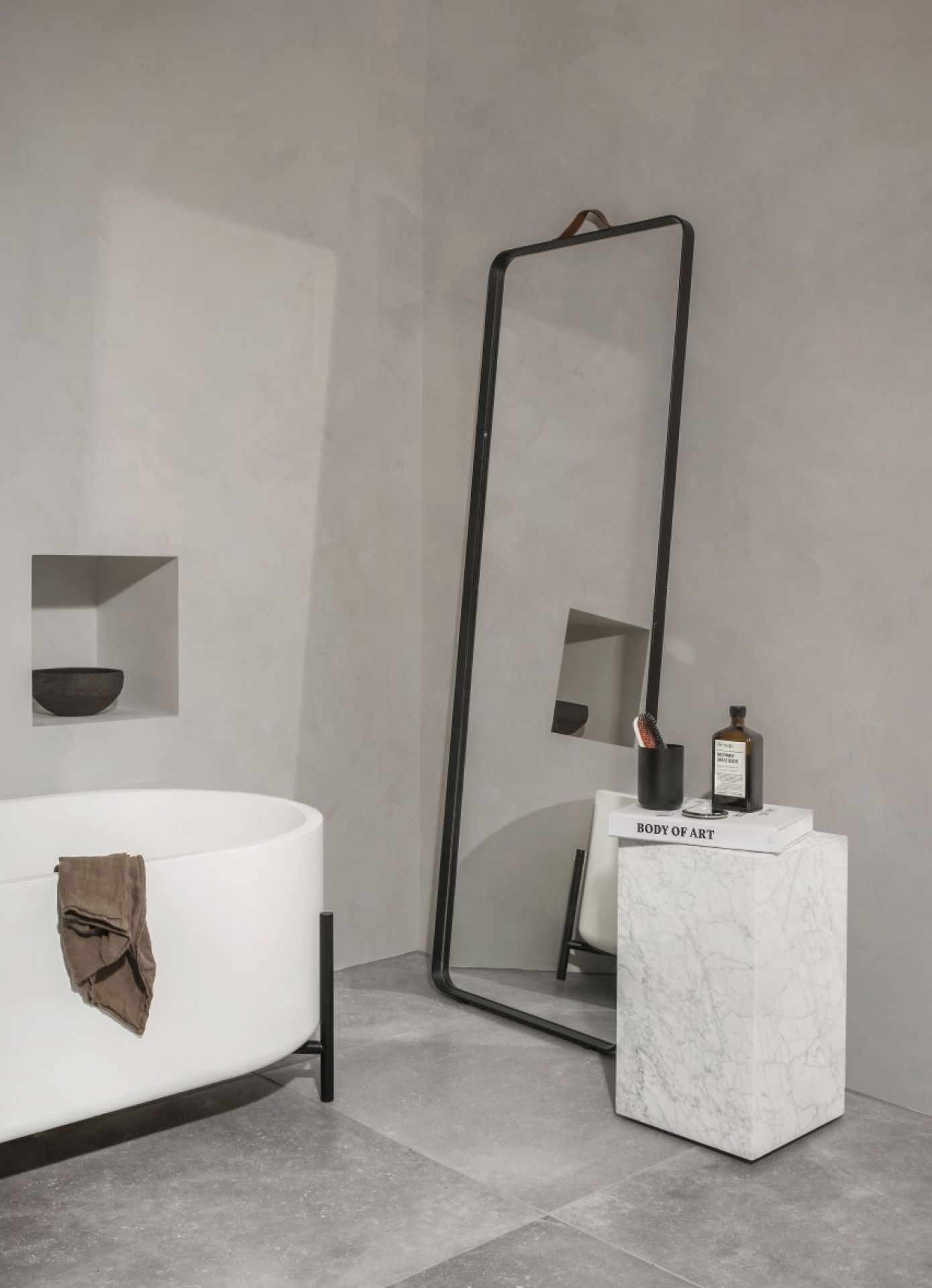 Badezimmer mit freistehender Badewanne und Norm Floor Mirror Wandspiegel von Audo mit schwarzem Rahmen.