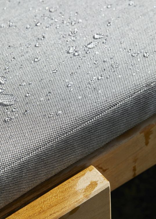 Detailaufnahme: Riviera Cushion Sitzkissen für Skagerak Sonnenliege mit wasserabweisendem Bezug und Wassertropfen.