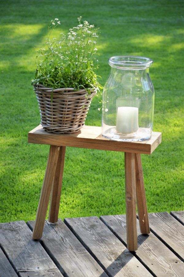 Milo Hocker von Jan Kurtz im Garten mit Pflanze und Windlicht auf Holzterrasse.