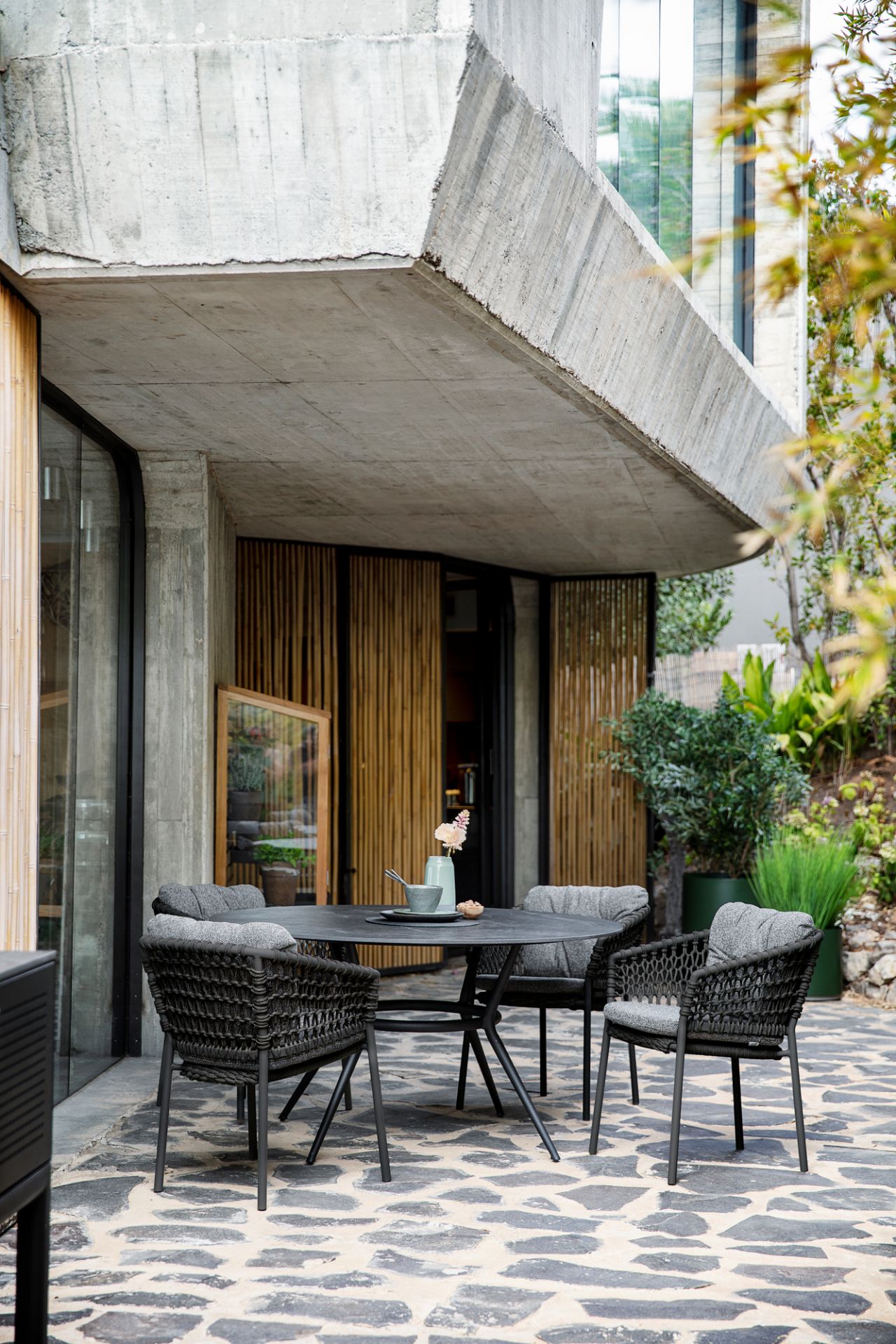 Außenaufnahme: Cane-Line Basket Sessel mit Umber brown Kissen auf einer Terrasse. Gartenmöbel.