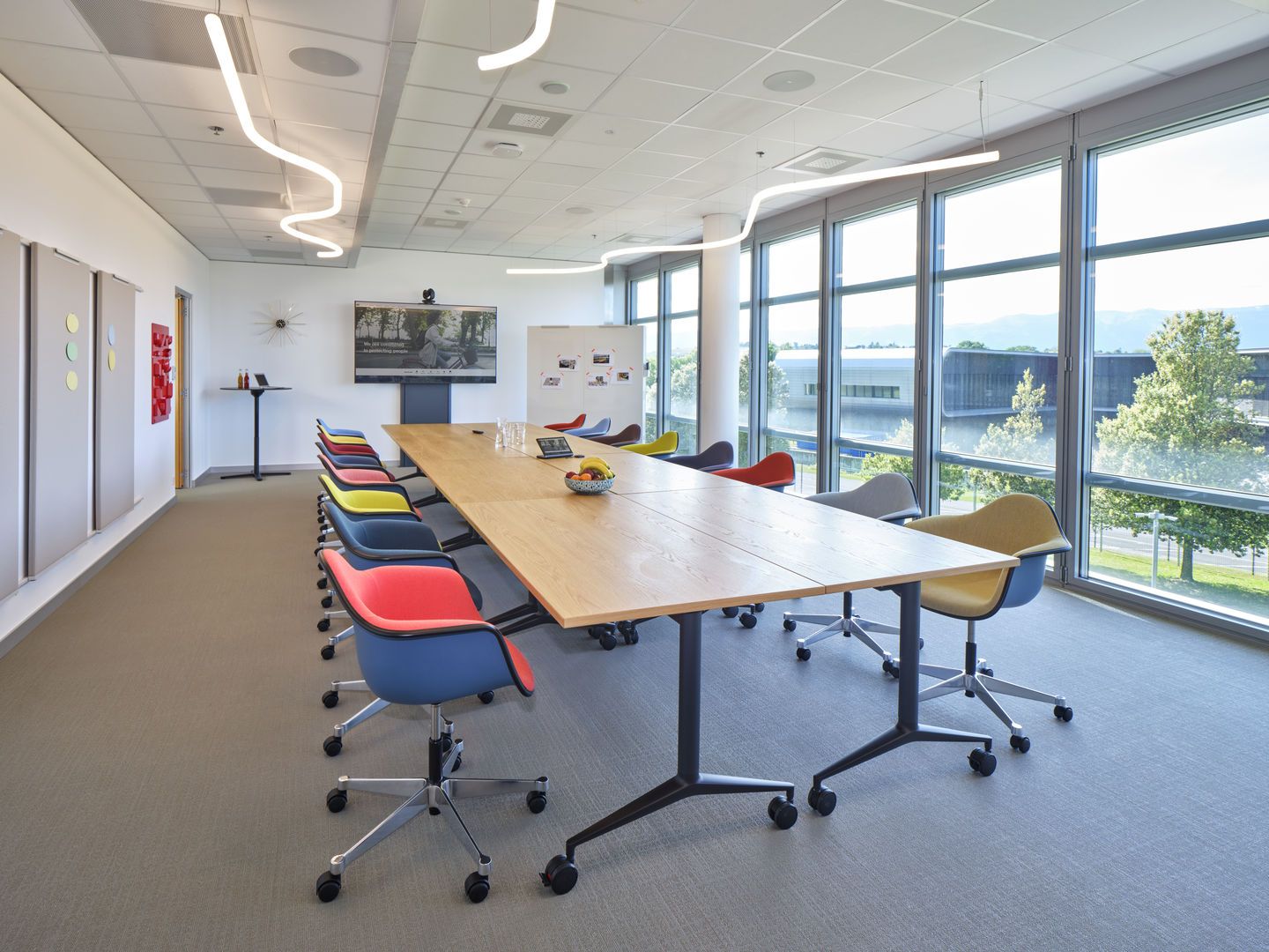 Besprechungsraum mit Eames Plastic Arm Chairs von Vitra, vollgepolstert und farbenfroh.