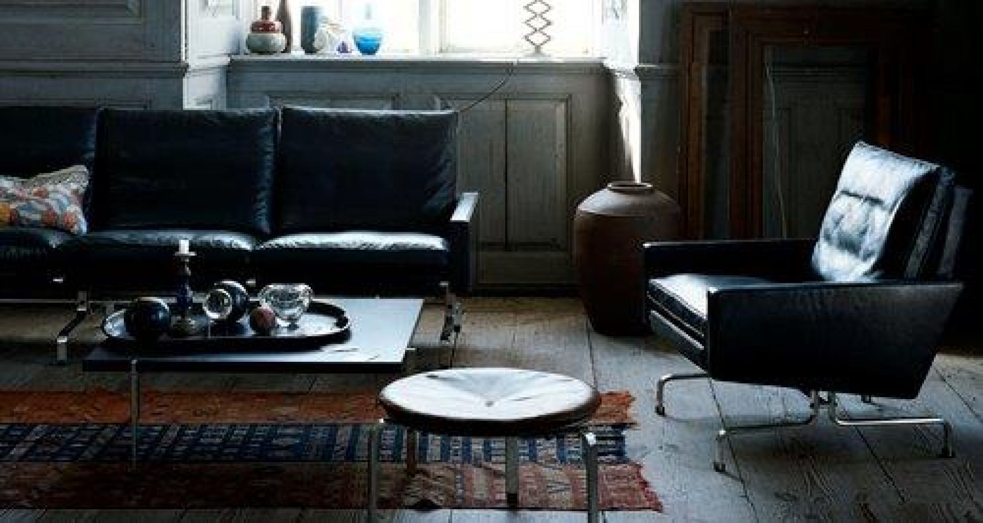 Schwarzer PK 31 Loungesessel von Fritz Hansen, Ledersessel im modernen Wohnzimmer mit Sofa.