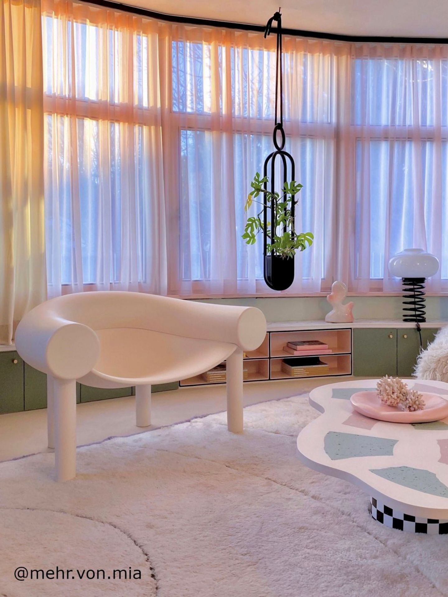 Heller Wohnraum mit modernem Sessel und Design-Couchtisch auf flauschigem Teppich.