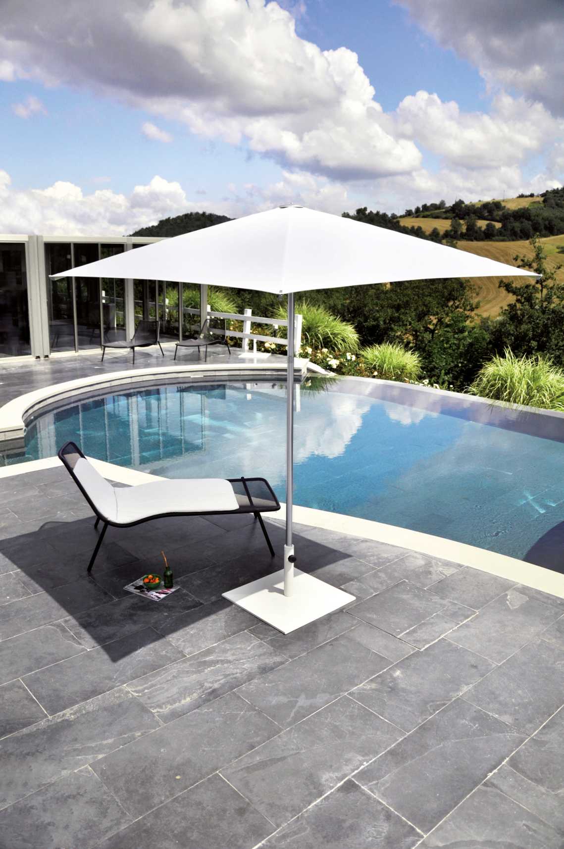 Weißer Shade Sonnenschirm von Emu neben Pool und Liege, ideal für den Garten.