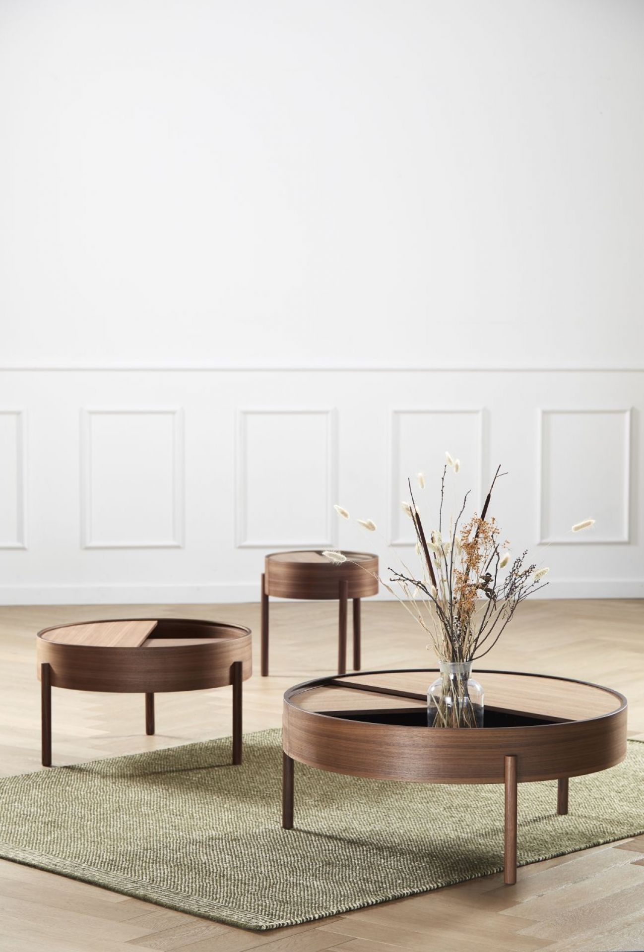 Drei Arc Coffee Tables von Woud aus Walnuss Holz in einem minimalistischen Wohnzimmer.