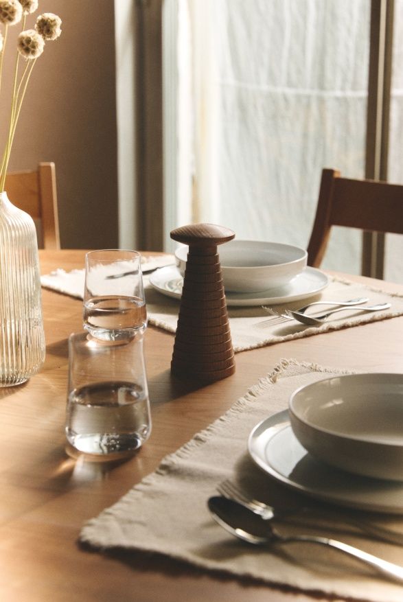 Nahaufnahme der Alessi Yucatan Salz- und Gewürzmühle aus Holz auf einem gedeckten Esstisch.